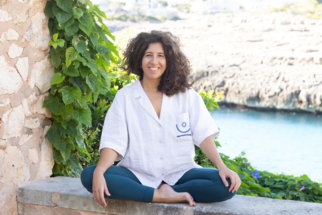 Retrato o foto de Ainara Cuesta sonriendo y en actitud de escucha activa en su consulta. Fisioterapeuta especializada en Portocolom